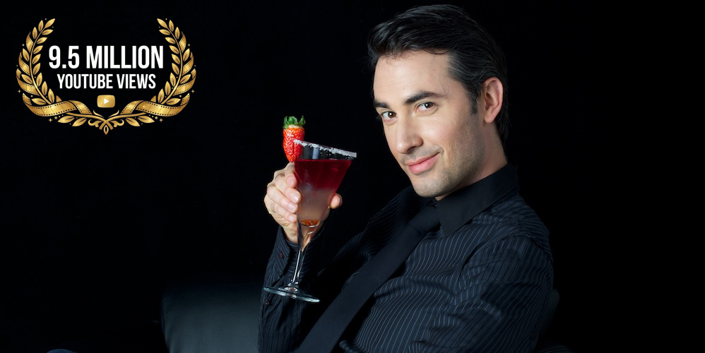 Man in black holding up a cocktail
